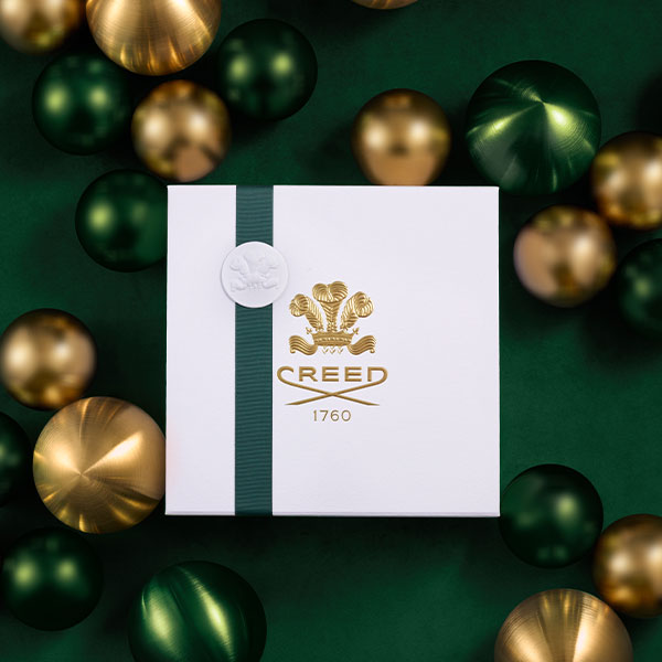 White Gift box with green ribbon with gold creed logo